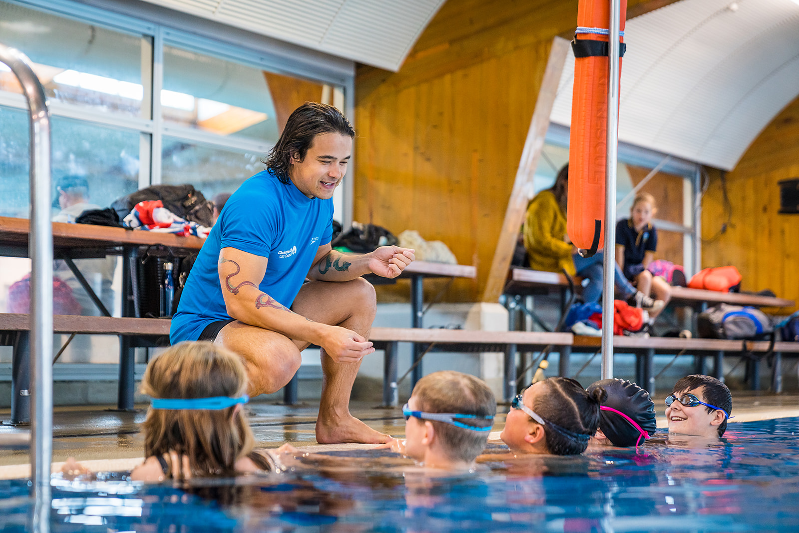 A male swim instructor helping a group of children at Christchurch Recreation and Sport pool. 