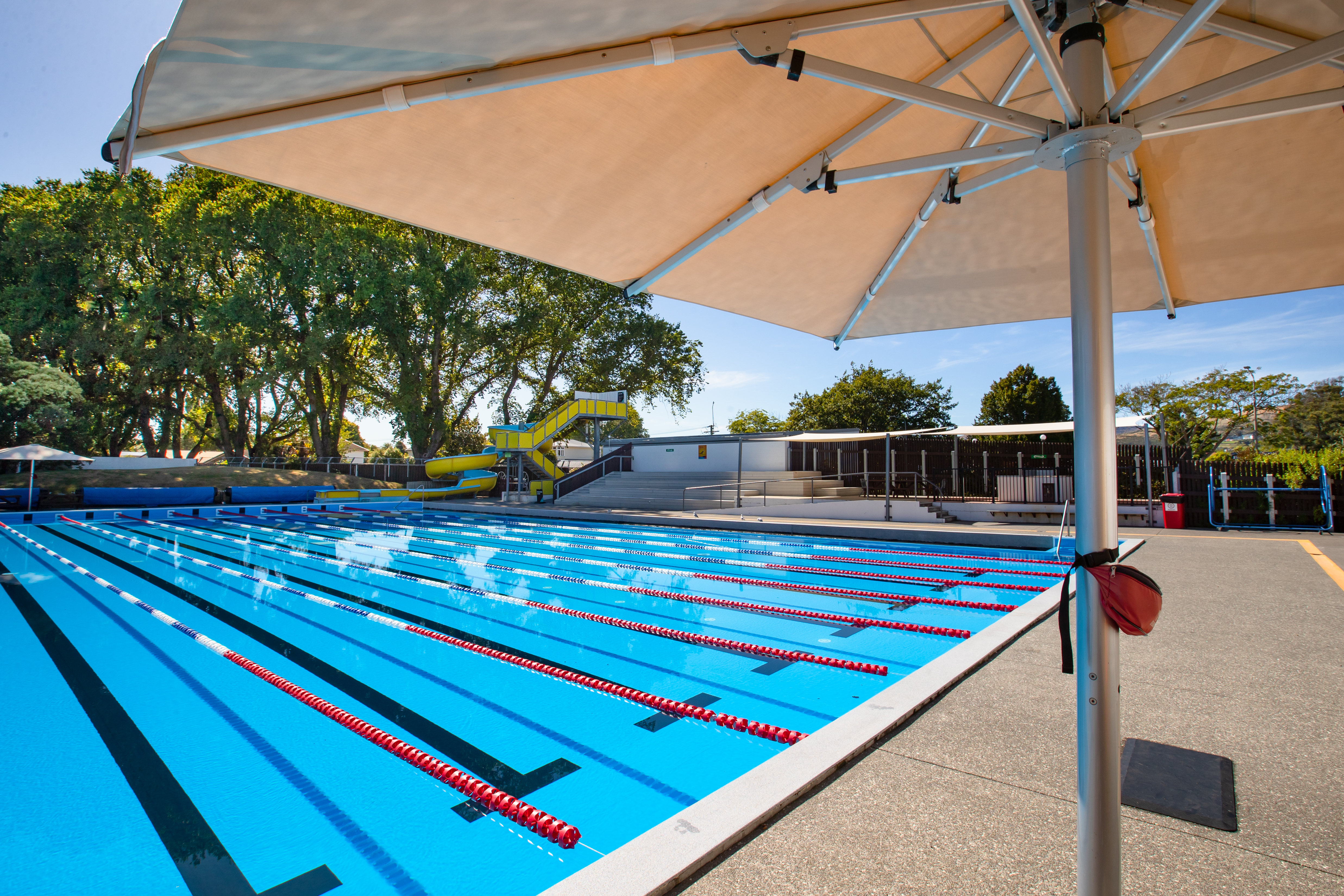 Waltham summer pool with lane pool and yellow and blue hydroslide. 