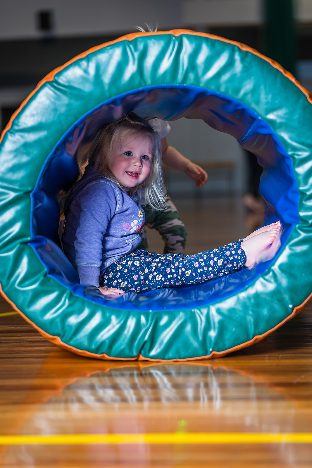 A toddler hiding inside a foam ring during a Tumbletimes class at Christchurch Recreation and Sport Centre.